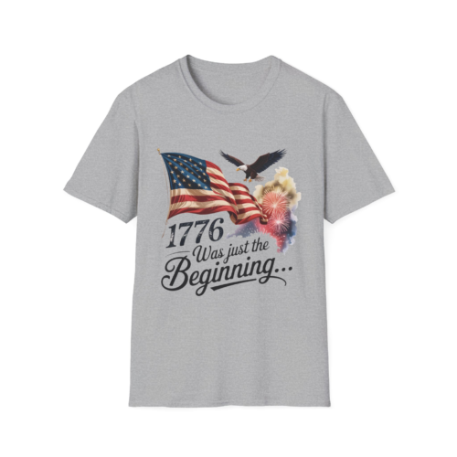 1807649187158710802_2048.webp A grey t-shirt with a graphic design featuring an American flag, a bald eagle in flight, and fireworks, along with the text '1776 Was just the Beginning...'.