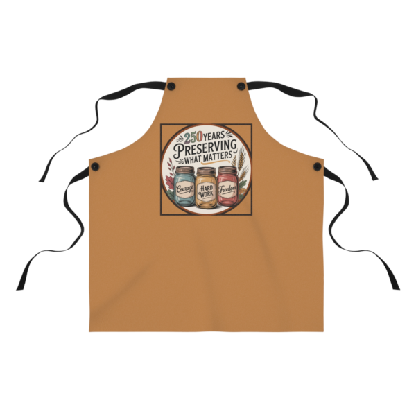 3523183907706096892_2048.webp A tan cooking apron with the words '250 years Preserving What Matters' surrounding three canning jars labeled 'Courage,' 'Hard Work,' and 'Freedom'.
