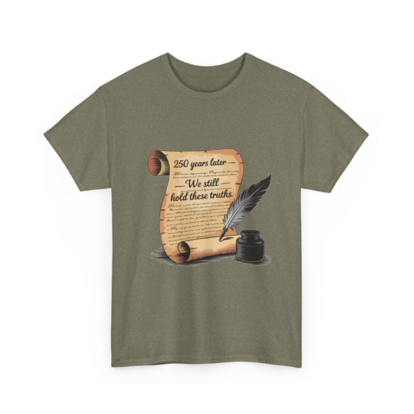 5423932435008427810_2048.webp Olive green t-shirt featuring a parchment scroll design with a quill and inkwell, displaying the phrase "We still hold these truths" amidst excerpts reminiscent of the Declaration of Independence.